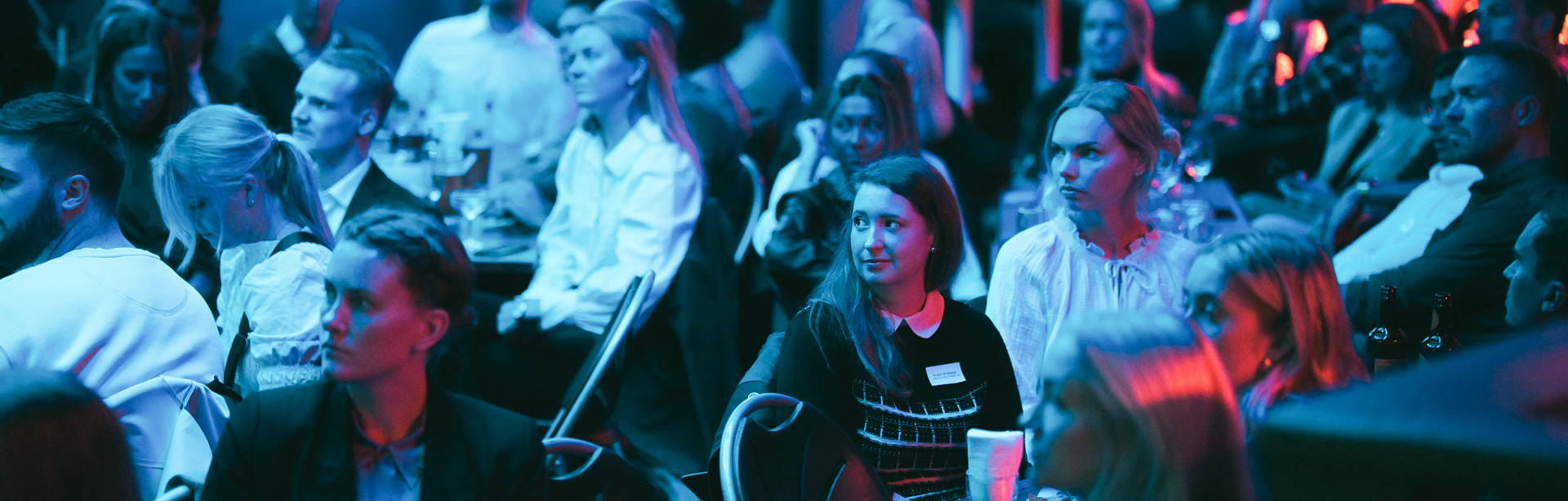 Young people gathered in a club attention towards scene